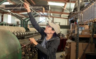 a woman works at a loom