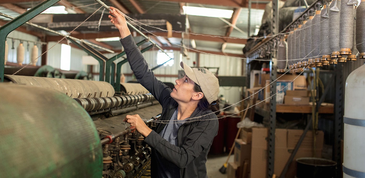 a woman works at a loom