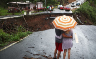 Survivors overlook a section of a collapsed road