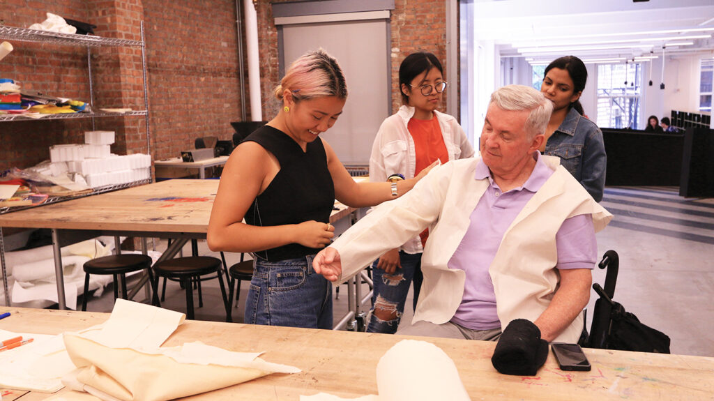Team Chris—(from left to right) design technologist Taeyeon Kim, fashion designer Abi Lierheimer, occupational therapist Neya John, and client Chris O’Donoghue—collaborate at Open Style Lab’s annual 10-week summer intensive at the Parsons School of Design. Chris is a retired television reporter and power chair user who is developing a tailored suit jacket with the team. Adaptations for the jacket include adjustments to the length, new sleeve shapes, highly technical fitting, and knit panels for stretch.