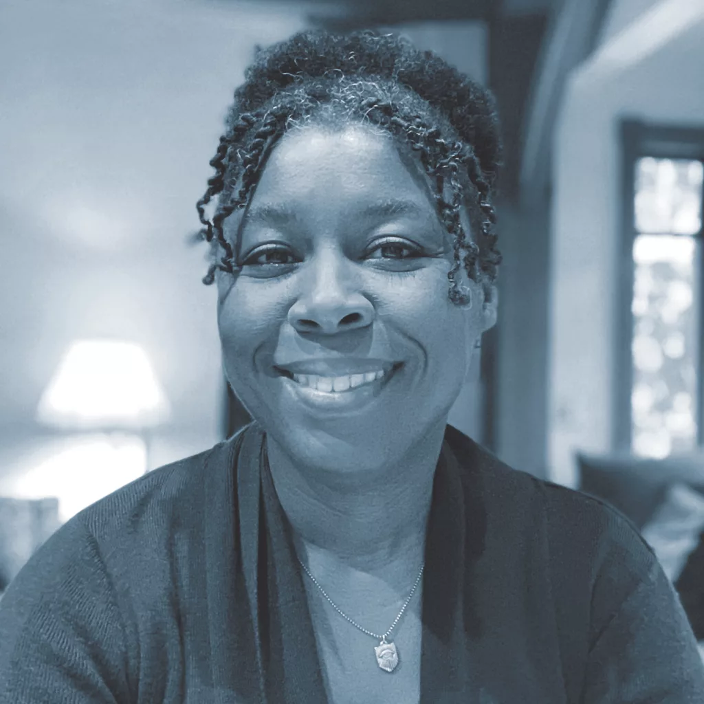 A greyscale photo of author Sherri L. Smith shows a close-up of her face, smiling directly at the camera. 