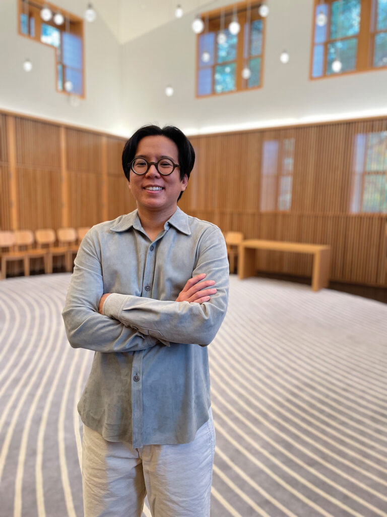 Frances S. Lee stands in the space he co-founded, smiling broadly with his arms crossed over his chest.