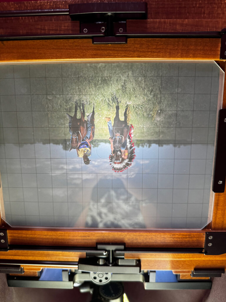 An image of a 19th-century camera with an upside-down image of two relay riders