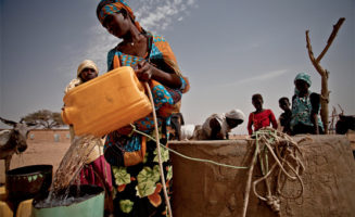 Refilling water container. Photo by Oxfam.