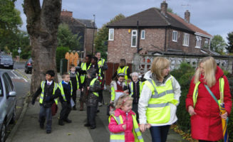 Parents help children walk to school in Salford