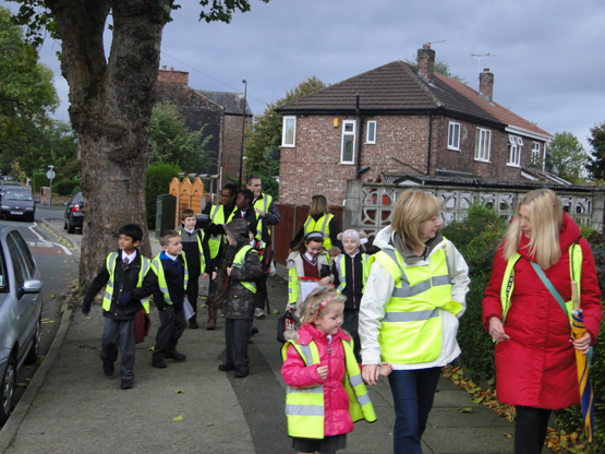 Parents help children walk to school in Salford