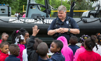 A police officer speaks with kids in North Charleston. Photo by Ryan Johnson.