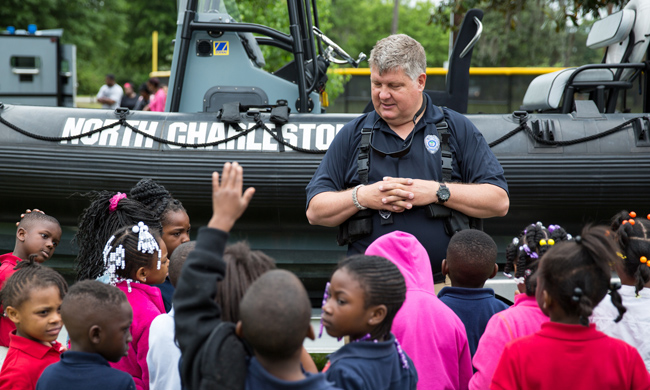 A police officer speaks with kids in North Charleston. Photo by Ryan Johnson.