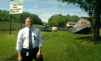 Ben Newhouse with solar array. Photo by Mary Hansen.